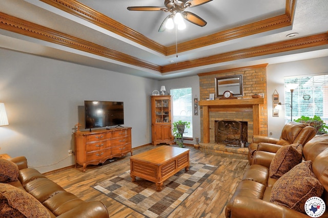 203 Peter Alan St, Wake Village, TX 75501 - living room with a raised ceiling, a ceiling fan, ornamental molding, wood-type flooring, and a fireplace