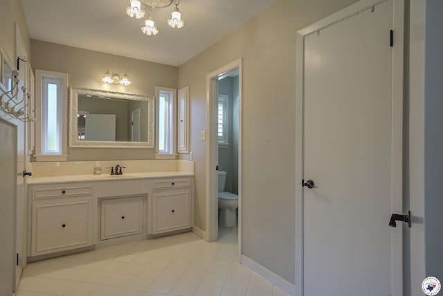 986 Texas Highway 77 W, Atlanta, TX 75551 - bathroom featuring vanity, a chandelier, toilet, tile patterned floors, and baseboards