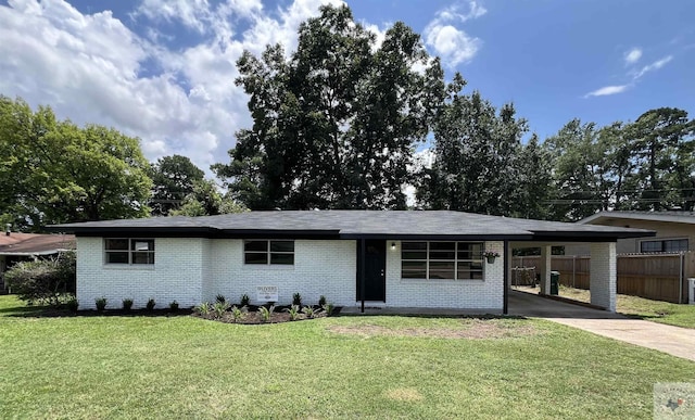 ranch-style home featuring concrete driveway, brick siding, a carport, and a front yard