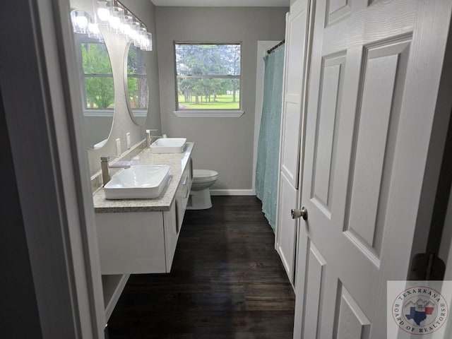 bathroom with hardwood / wood-style flooring, toilet, and vanity