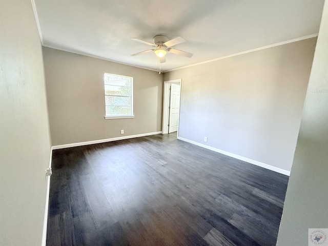 spare room featuring a ceiling fan, dark wood finished floors, crown molding, and baseboards