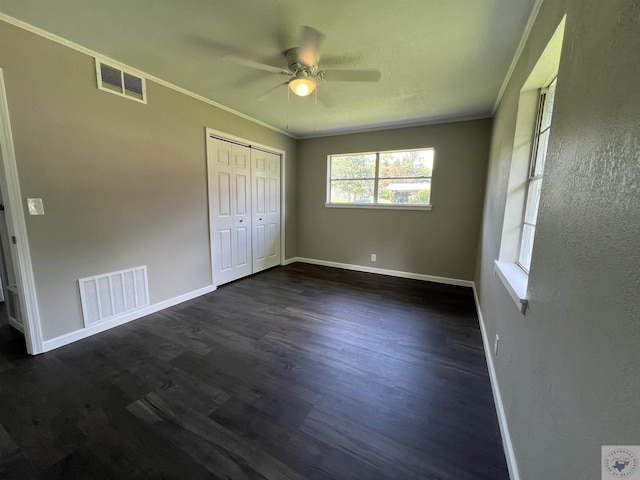 unfurnished bedroom featuring dark hardwood / wood-style flooring, a closet, ceiling fan, and ornamental molding