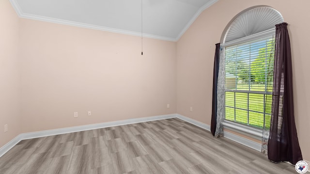 empty room with a wealth of natural light, crown molding, vaulted ceiling, and light wood-type flooring
