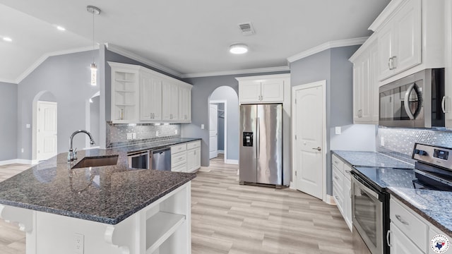 kitchen featuring open shelves, arched walkways, appliances with stainless steel finishes, and a sink