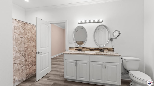 bathroom with baseboards, wood finished floors, ornamental molding, and toilet