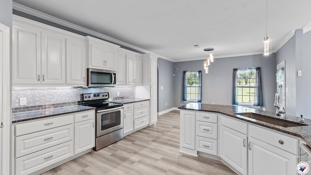 kitchen featuring white cabinets, ornamental molding, a sink, and appliances with stainless steel finishes