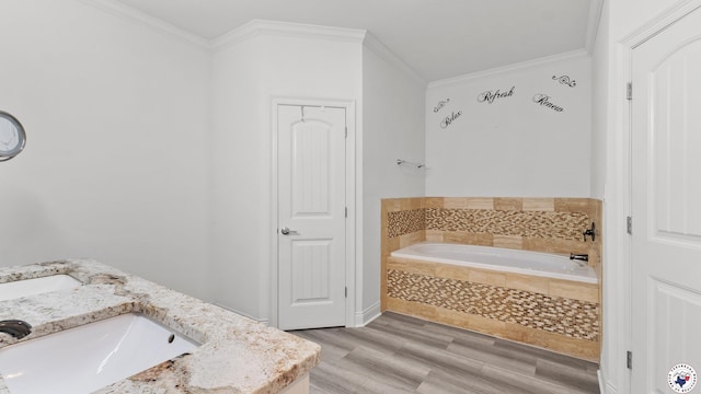 bathroom with a garden tub, wood finished floors, a sink, and crown molding