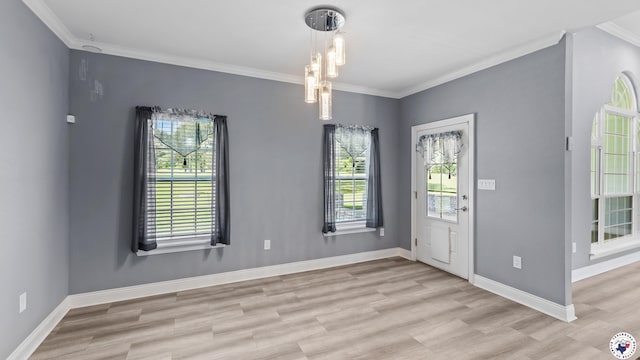 entrance foyer with light wood finished floors, baseboards, a chandelier, and crown molding