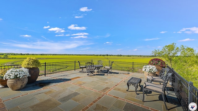 view of patio / terrace featuring a rural view and fence