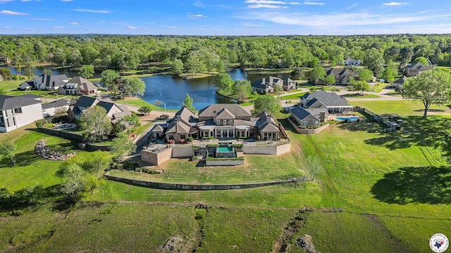 drone / aerial view with a forest view and a water view