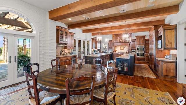 dining room featuring beamed ceiling, french doors, a notable chandelier, and dark wood-type flooring