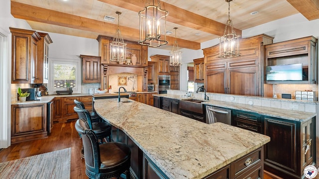 kitchen featuring dark wood finished floors, stainless steel appliances, an inviting chandelier, a large island, and a sink