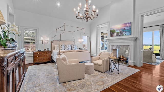 bedroom with a chandelier, wood finished floors, and multiple windows
