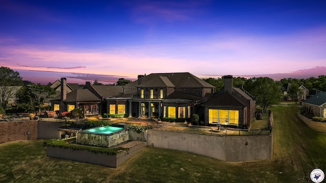 rear view of property with a patio, a chimney, an in ground hot tub, and a balcony