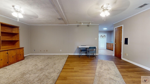 living room with ceiling fan, a textured ceiling, hardwood / wood-style flooring, and crown molding