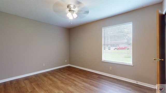 empty room with ceiling fan, a wealth of natural light, and light hardwood / wood-style flooring