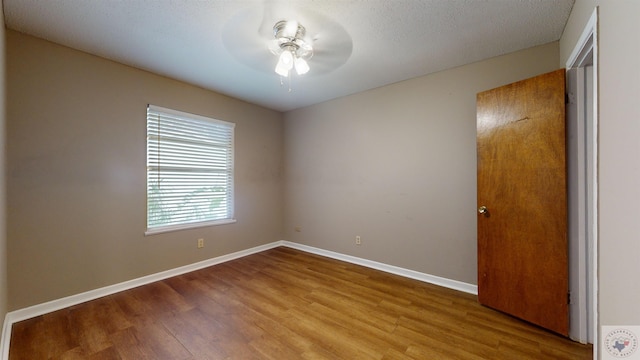 spare room featuring hardwood / wood-style flooring, a textured ceiling, and ceiling fan