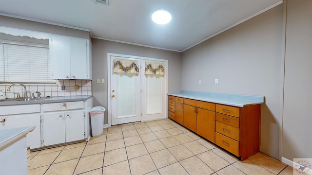 kitchen featuring sink, white cabinetry, ornamental molding, and decorative backsplash