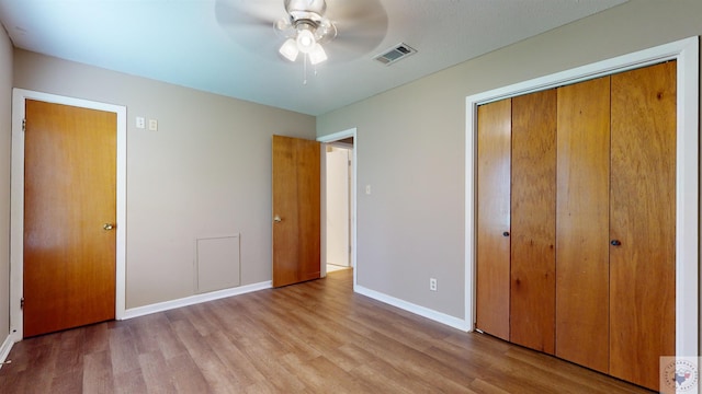 unfurnished bedroom featuring light hardwood / wood-style flooring, a closet, and ceiling fan