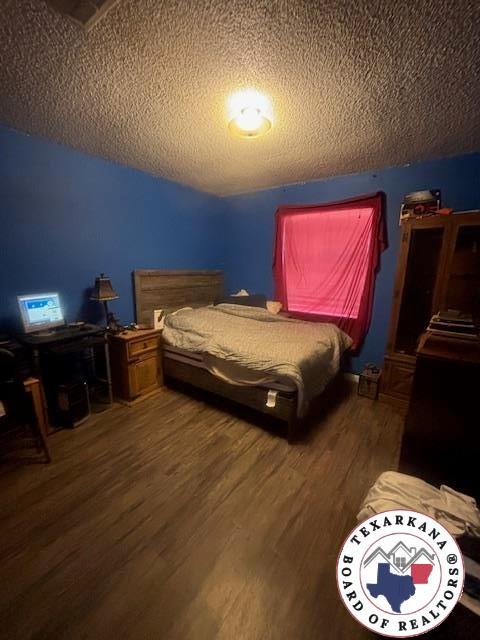 4903 Charleston St, Texarkana, AR 71854 - bedroom featuring wood finished floors and a textured ceiling