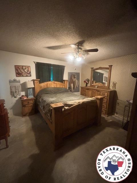 4903 Charleston St, Texarkana, AR 71854 - bedroom with a textured ceiling, dark colored carpet, and a ceiling fan