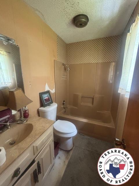 4903 Charleston St, Texarkana, AR 71854 - bathroom featuring a textured ceiling, vanity, and shower / bath combination