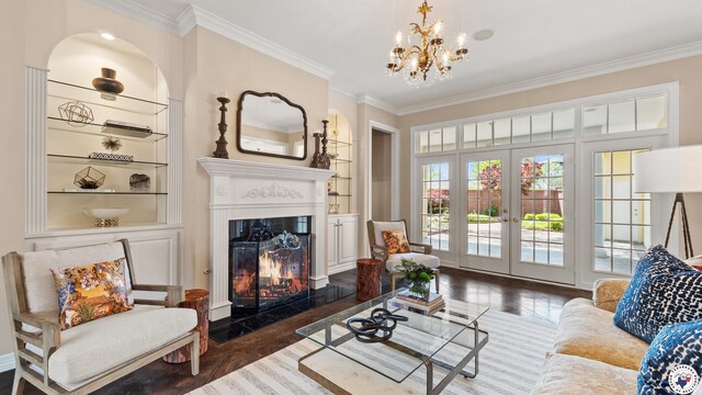 11 Dogwood Pl, Texarkana, TX 75503 - living area with crown molding, a fireplace with flush hearth, a chandelier, wood finished floors, and french doors