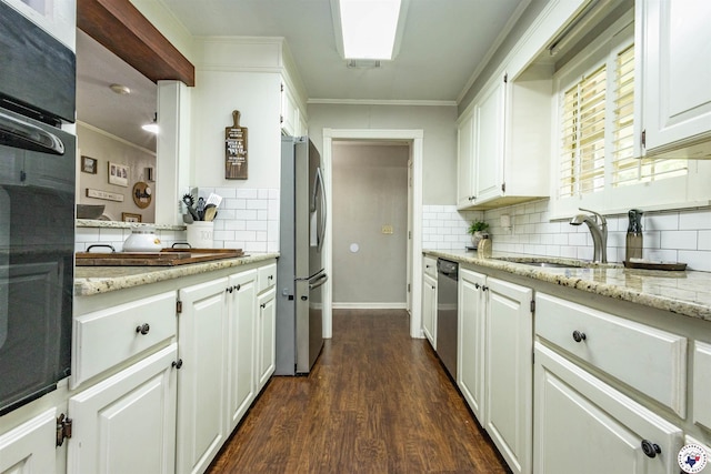 205 S Park Dr, New Boston, TX 75570 - kitchen with stainless steel appliances, ornamental molding, decorative backsplash, dark wood finished floors, and white cabinetry