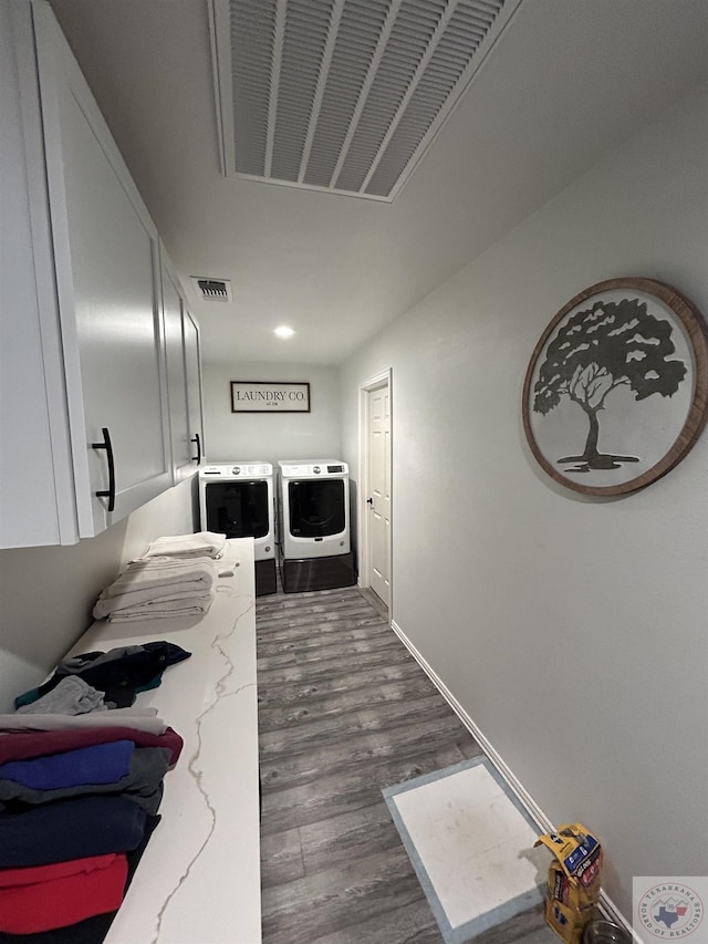 hall with visible vents, washing machine and dryer, dark wood-type flooring, and baseboards