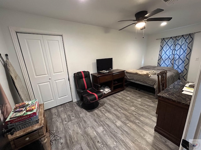 bedroom with ceiling fan, hardwood / wood-style flooring, and a closet