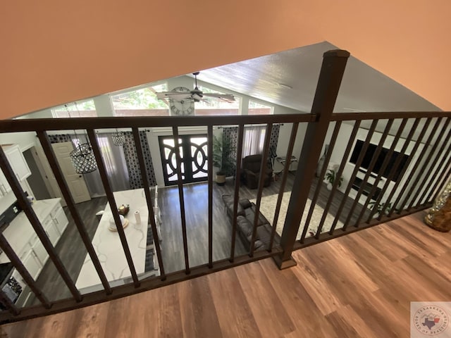 stairway with ceiling fan, wood-type flooring, and lofted ceiling