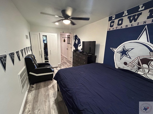 bedroom featuring visible vents, a ceiling fan, and wood finished floors