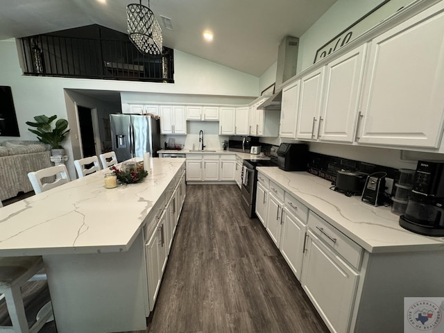 kitchen featuring white cabinets, appliances with stainless steel finishes, a kitchen island, hanging light fixtures, and a breakfast bar area