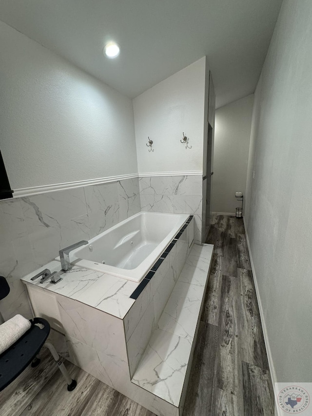 bathroom featuring hardwood / wood-style floors and tiled bath