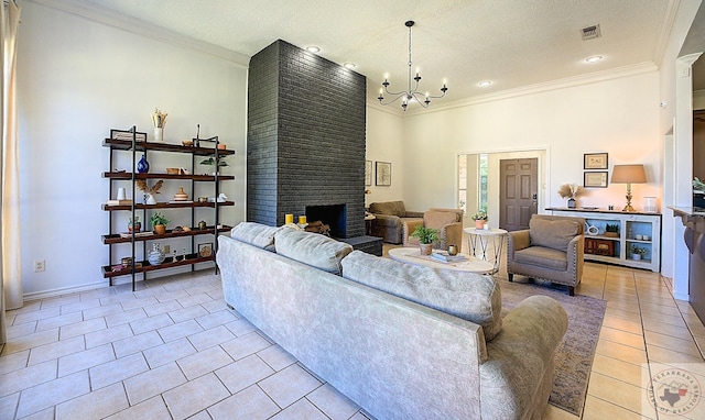 tiled living room featuring ornamental molding, a brick fireplace, a textured ceiling, and a notable chandelier