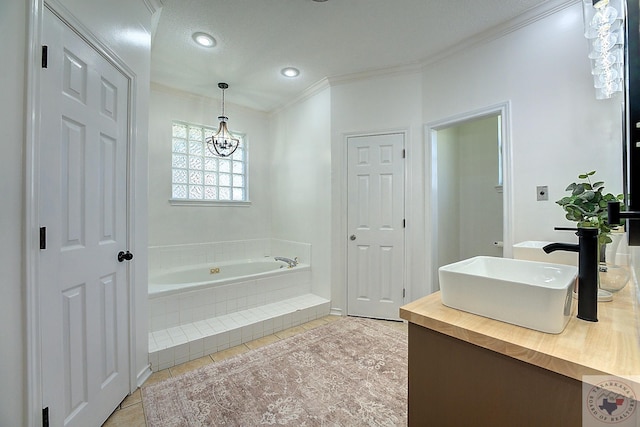 bathroom with crown molding, tile patterned flooring, an inviting chandelier, vanity, and tiled bath