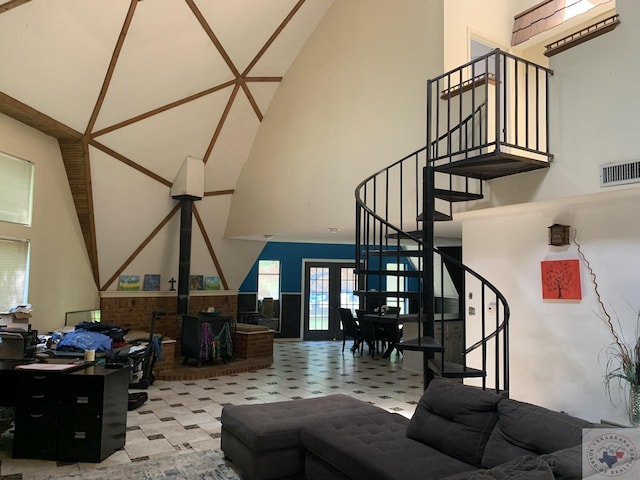 living room with a wood stove and high vaulted ceiling