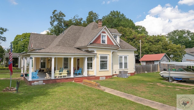 rear view of house with covered porch and a lawn