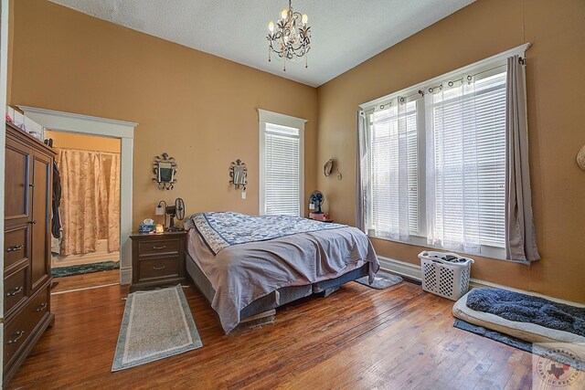 2804 Walnut St, Texarkana, TX 75503 - bedroom featuring a textured ceiling, dark hardwood / wood-style floors, and a notable chandelier