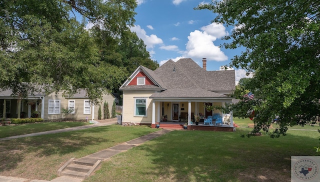 view of front of home with covered porch and a front lawn