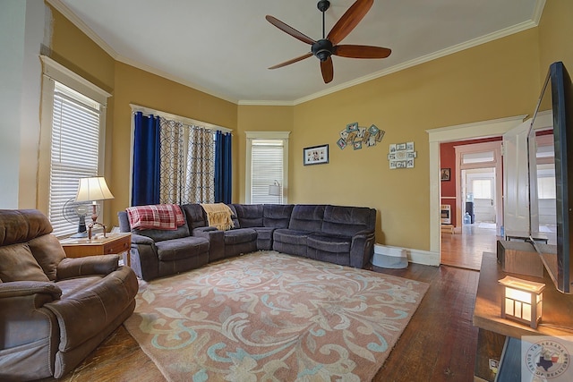 living room featuring ceiling fan, a healthy amount of sunlight, ornamental molding, and dark hardwood / wood-style floors