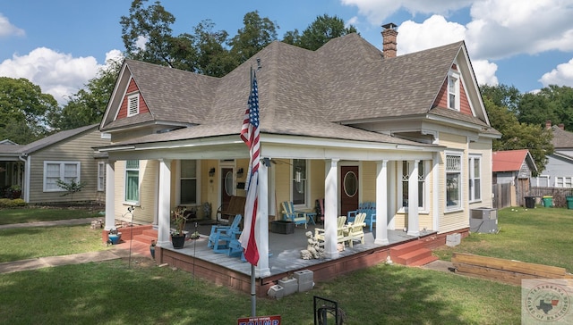 back of house featuring a lawn and a porch