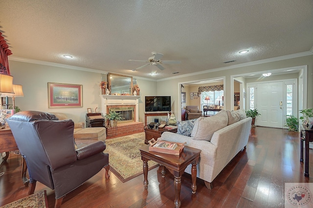 living room featuring a fireplace, a textured ceiling, ornamental molding, ceiling fan, and dark hardwood / wood-style floors