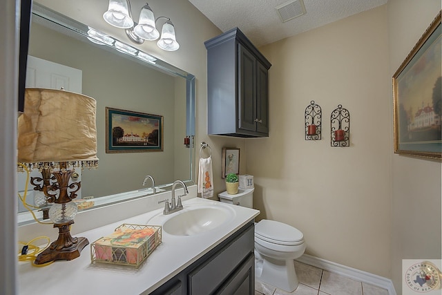 bathroom with vanity, toilet, tile patterned floors, and a textured ceiling