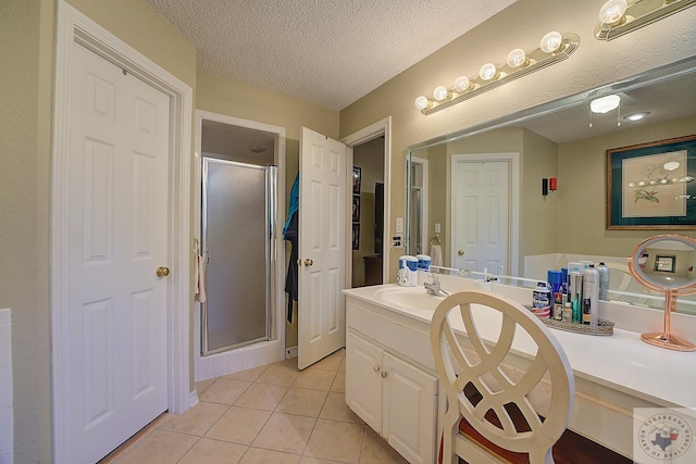 bathroom with a shower with door, a textured ceiling, vanity, and tile patterned flooring