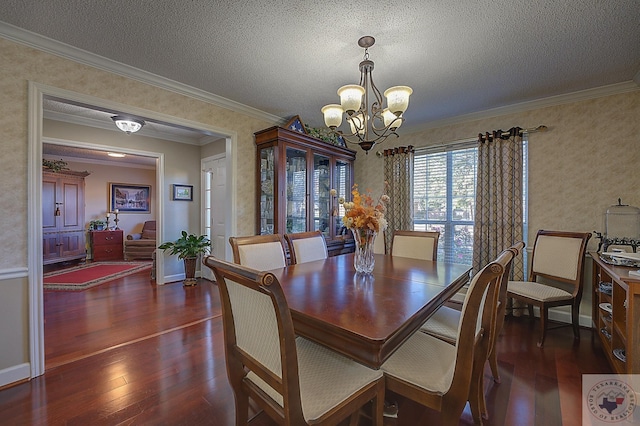 dining room featuring a textured ceiling, dark wood-type flooring, a chandelier, and ornamental molding