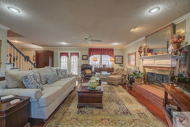 living room with dark wood-type flooring, a textured ceiling, and crown molding