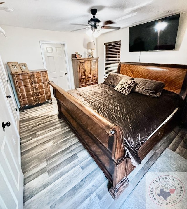 bedroom with wood-type flooring, a textured ceiling, and ceiling fan