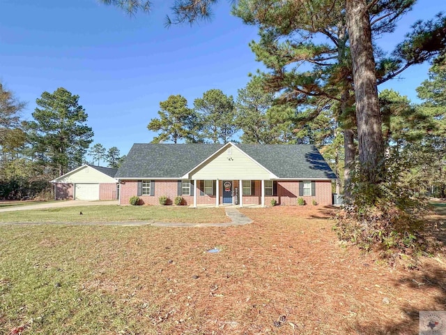 single story home with covered porch, a garage, and a front lawn