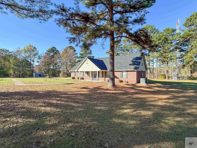 view of front facade featuring central air condition unit, a front lawn, and covered porch